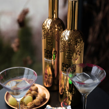 Two martini glasses with lipstick marks and two vodka bottles in the background