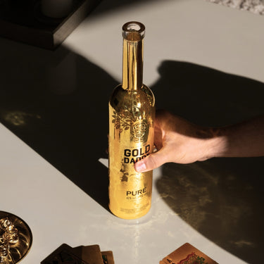 Hand holding a branded Gold Daddy Vodka bottle