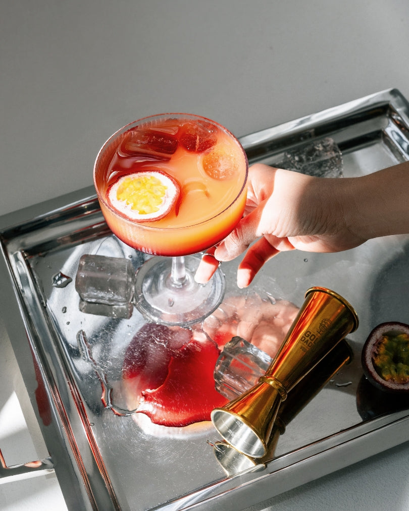 Pornstar Martini cocktail with passion fruit on a tray with ice